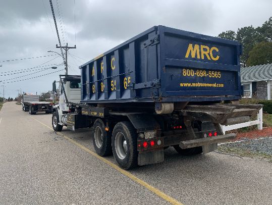 MRC roll-off dumpster being delivered on a hook-lift truck